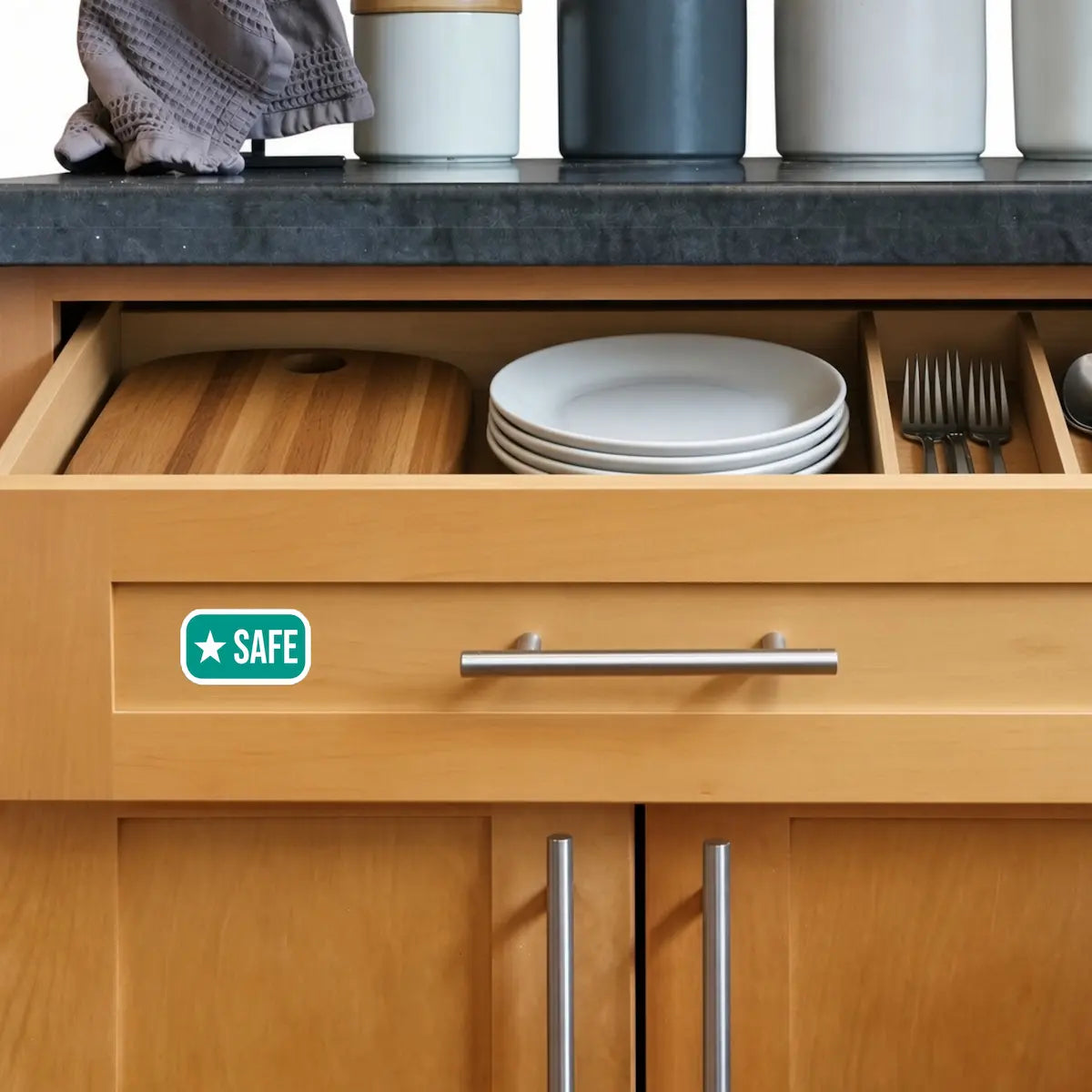 Safe sticker on a kitchen drawer front, marking a FARE-recommended food allergy safety zone for dedicated cutting board, plates and utensils.