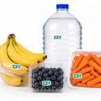 Four grocery items on a white background: bagged bananas, bottled water, packaged blueberries, and carrot sticks. A small rectangular Safe Food allergy sticker is placed on each package.