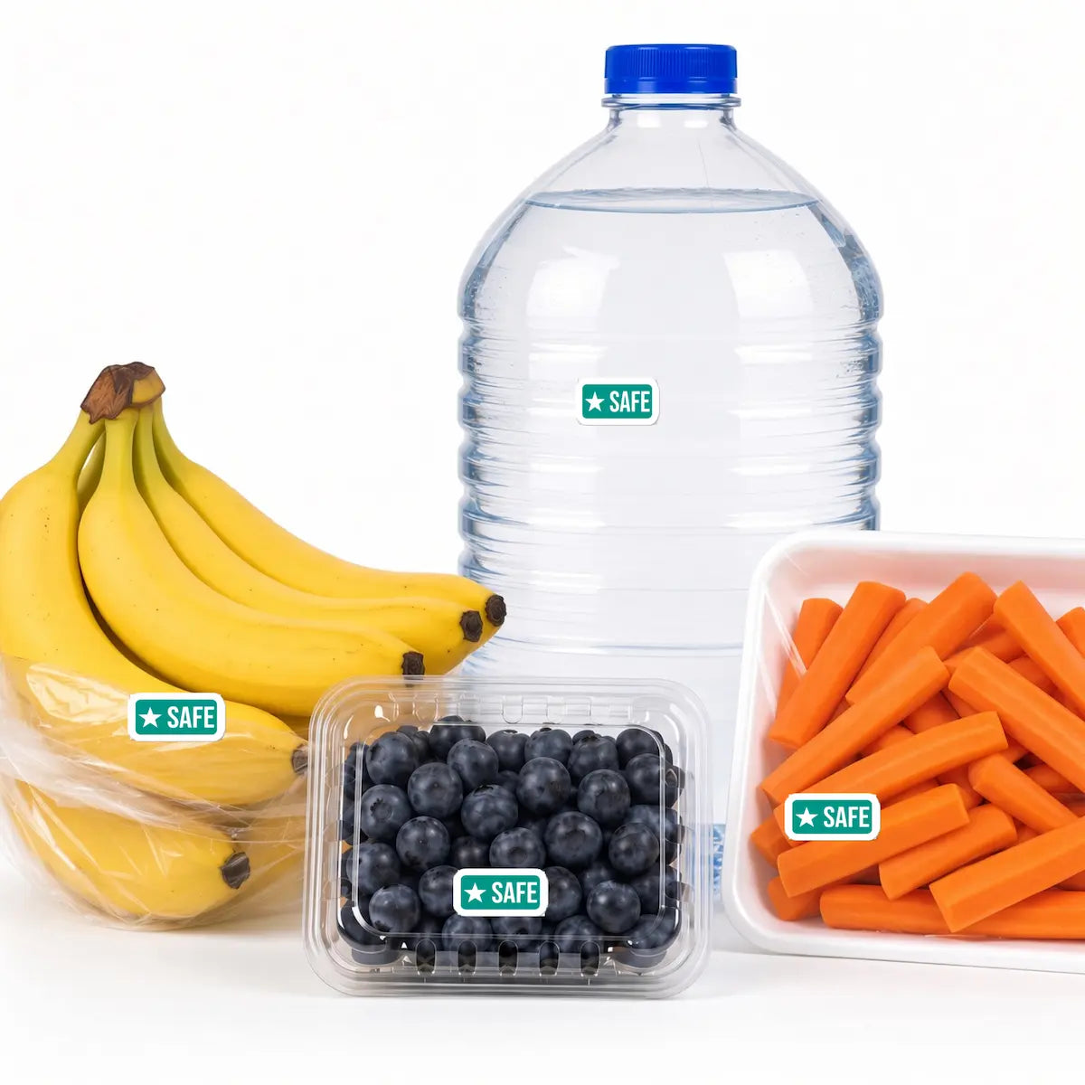 Four grocery items on a white background: bagged bananas, bottled water, packaged blueberries, and carrot sticks. A small rectangular green-star Safe Food allergy sticker is placed on each package.